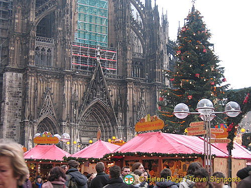 A busy Christmas market set against Cologne Dom and its Christmas tree