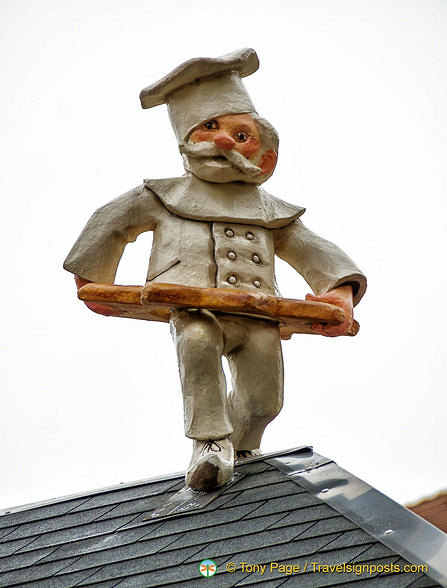 A baker decorates this Christmas market stall