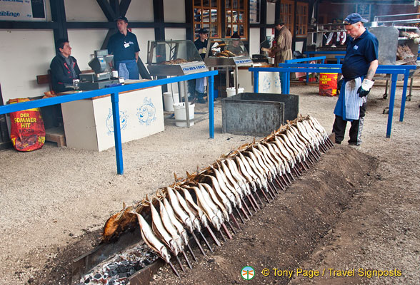 Neat rows of steckerlfisch being grilled