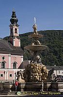 Baroque Residenz fountain with St. Michael's Church in the background