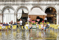 Waiters decked in gumboots continue to serve Aperol Spritz 