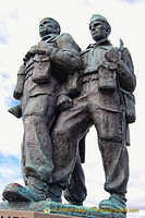 Three figures on a stone plinth