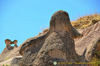 Napoleon's hat in the foreground and two lovers kissing in the distant left