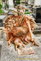 A wood-carved pelican tombstone